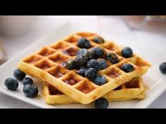 two waffles with blueberries on top sitting on a plate