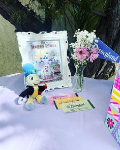 a stuffed animal sitting on top of a table next to a vase filled with flowers