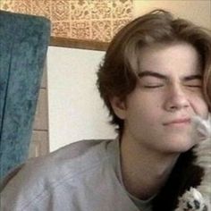 a young man holding a cat in his arms