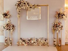 a wedding ceremony setup with flowers and gold frames