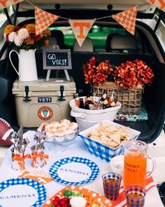 a tailgate party in the back of a car with food and drinks on it