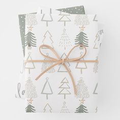 two wrapping paper wrapped in twine with christmas trees on them