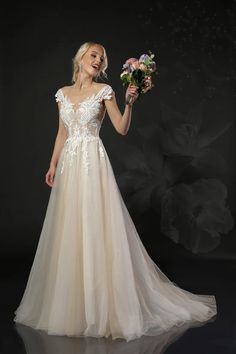 a woman in a wedding dress holding flowers