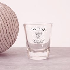 a shot glass sitting next to a striped ball