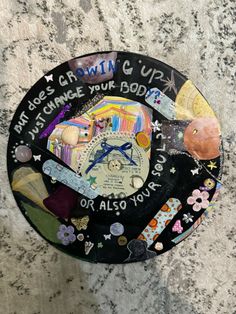 a black plate with words and pictures on it sitting on a marble counter next to a wall