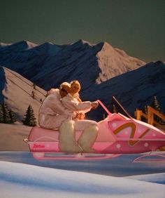 two people on a pink sled in the snow