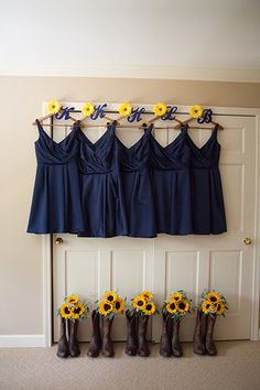 the bridesmaids'dresses and sunflowers are lined up on the wall