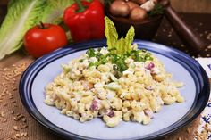 macaroni salad on a blue plate with lettuce and tomatoes