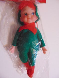 a plastic doll with red hair and blue eyes sitting on top of a plastic bag