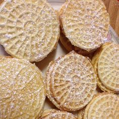 there are many cookies on the plate with powdered sugar