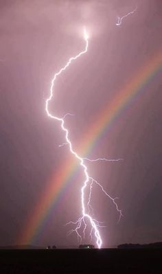 a rainbow and some lightning in the sky