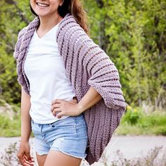 a woman in shorts and a white t - shirt smiles while posing for the camera