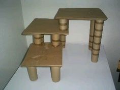 three small wooden tables sitting on top of a white tablecloth covered floor next to a wall