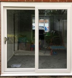 an open sliding glass door in front of a brick wall