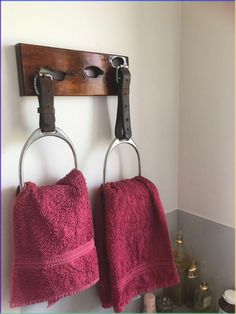 two towels hanging on hooks in a bathroom