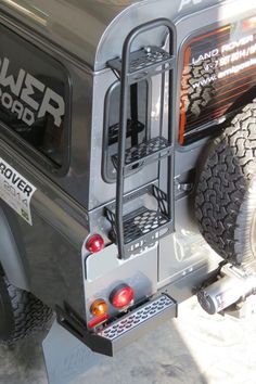 the back end of a silver truck with an extra tire guard on it's side