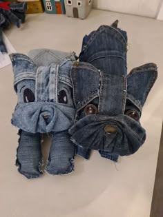 two stuffed animals made out of jeans sitting on top of a table