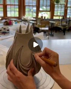 a person is making a vase out of clay