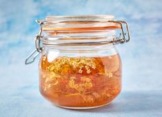 a glass jar filled with gold flakes on top of a blue tablecloth covered surface