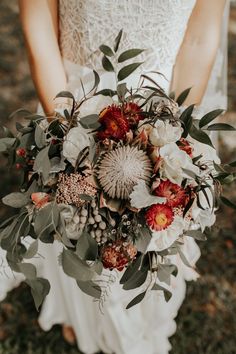 a bridal holding a bouquet of flowers and greenery