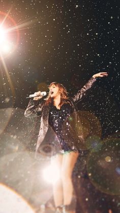 a woman standing on top of a stage holding a microphone