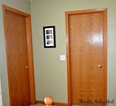 two wooden doors are open in a room with carpeted flooring and framed pictures on the wall