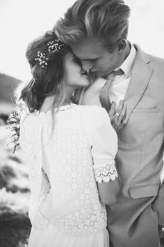 a man in a suit and tie kissing a woman's face with her eyes closed