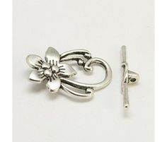 a pair of silver tone flower shaped ear studs on a white background with clipping