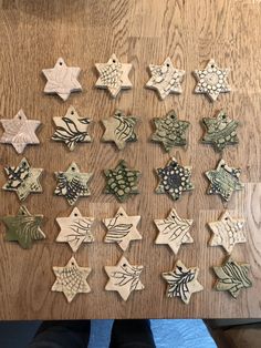 a person is sitting at a table with many small ornaments on it, all in different shapes and sizes