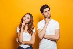 a man and woman standing next to each other with their chins crossed looking at the camera