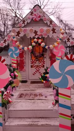 a decorated house with candy canes and lollipops on the front steps