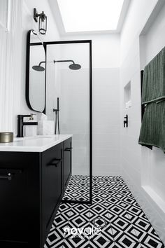 a black and white bathroom with skylight above the shower area is pictured in this image