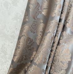 a close up view of a curtain with gold and silver floral designs on the fabric