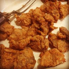 some fried food on a plate with a fork and knife