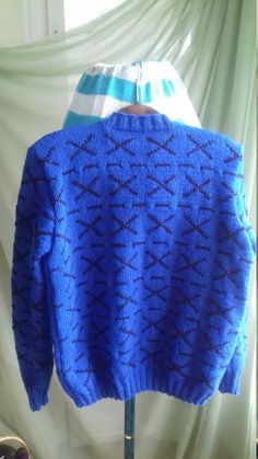 a blue sweater on a stand in front of a window