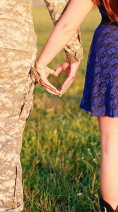 two people holding hands while standing in the grass