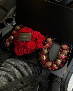 roses and chocolates are arranged in the car's center console, along with a black box that says i love you