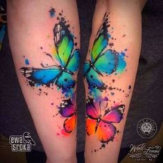 two colorful butterfly tattoos on both legs with watercolor splashes and splatters