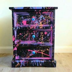 an old dresser with paint splattered all over it's sides and drawers