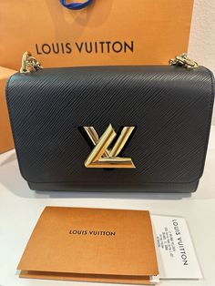 This beautiful Louis Vuitton Twist Shoulder Bag is crafted from high-quality black leather with a stylish Epi finish. It features a magnetic closure and a gold metal handle with a 21.2-inch strap drop. The bag measures 9 inches in width, 6.7 inches in height, and 3.7 inches in depth, making it the perfect medium-sized accessory for any occasion. The bag's interior is lined with black microfiber and features a luxurious gold hardware color. It has a rectangular shape and is part of the Louis Vuitton Twist product line. This elegant shoulder bag is perfect for women who want to add a touch of sophistication to their outfit. Brand new never worn comes with original dust bag and box Louis Vuitton Twist Mm Black, Louis Vuitton Twist, Magnetic Closure, Gold Hardware, Gold Metal, Dust Bag, Black Leather, Louis Vuitton, Shoulder Bag