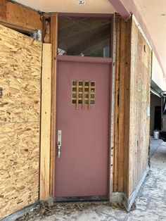 a pink door in the corner of a building under construction