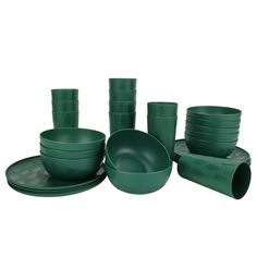 green dishes and cups are stacked on top of each other in front of a white background