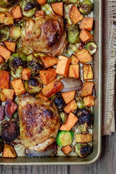 a roasting pan filled with chicken, brussel sprouts and sweet potatoes