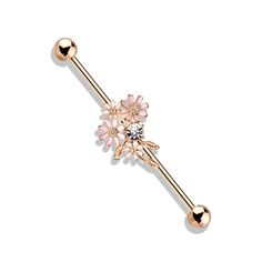 a pink and gold flower belly ring with two balls on the end, attached to a ball