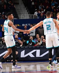 two basketball players shaking hands on the court