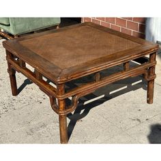 an old wooden coffee table sitting on the side of a street next to a brick building