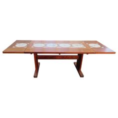 a wooden table with plates on it and white walls in the backgroung