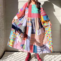 a woman standing in front of a building wearing a colorful dress