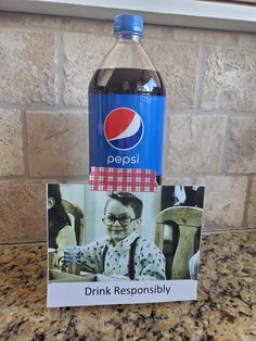 a bottle of pepsi water sitting on top of a counter next to a sign that says drink responsity