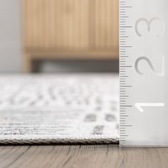 a ruler is on the floor next to a rug